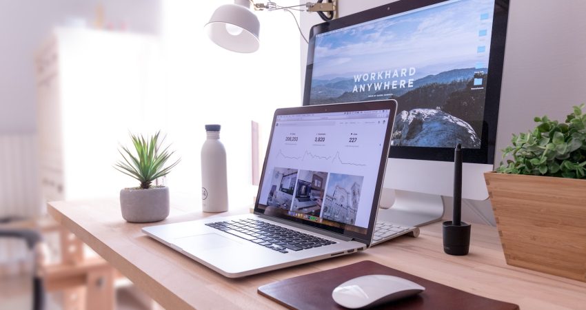 MacBook Pro on table beside white iMac and Magic Mouse